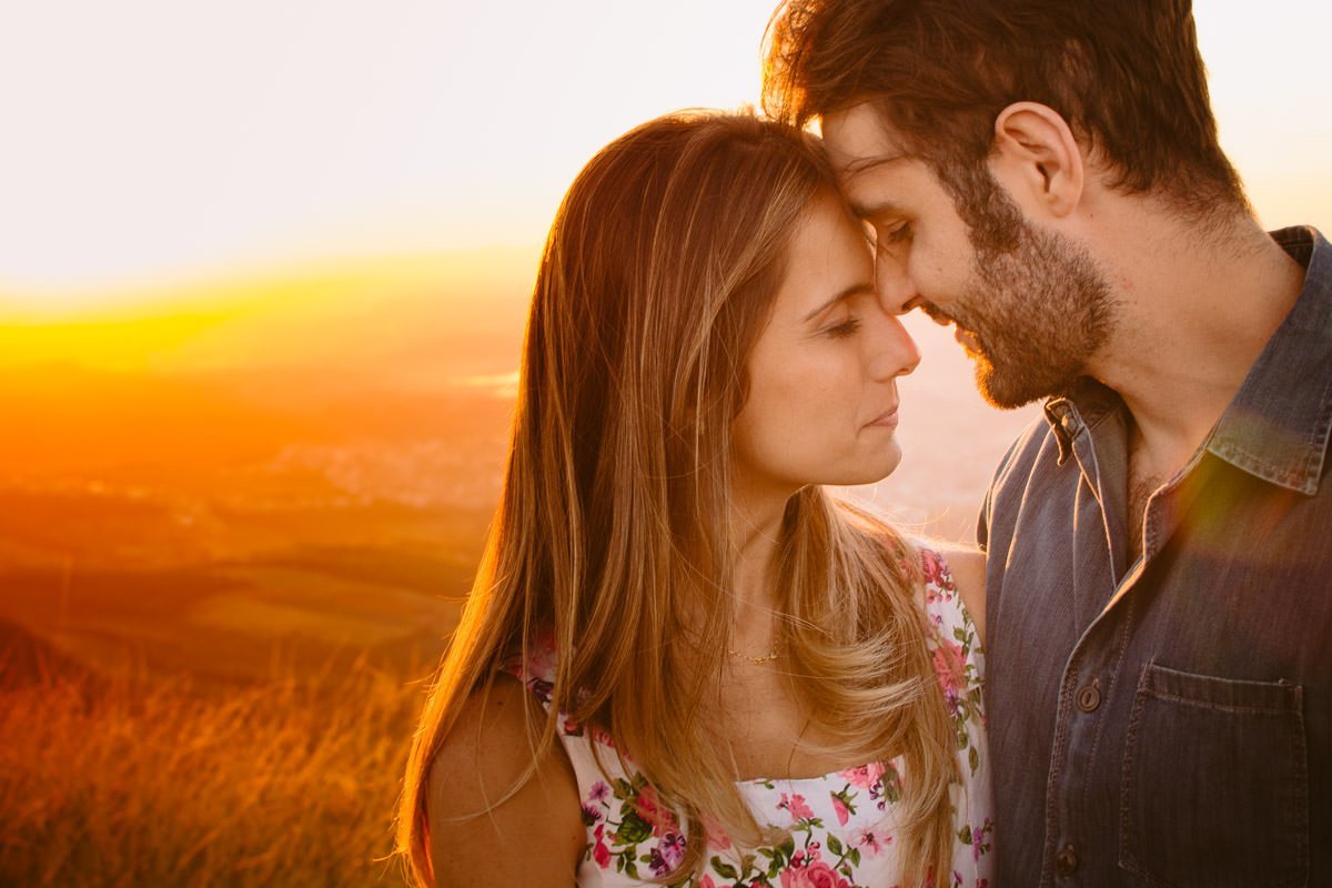 fotografia de ensaio pré-casamento no pôr-do-sol em belo horizonte. serra do rola moça ao fundo,=.